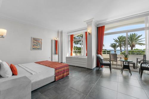 a bedroom with a bed and a view of the ocean at Club Hotel Rama in Beldibi