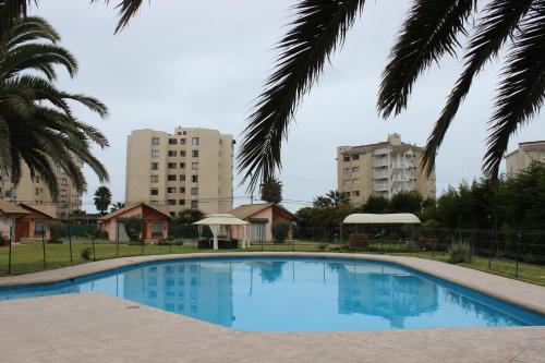 a large swimming pool with buildings in the background at Apart Hotel Y Cabanas Vegasur in La Serena