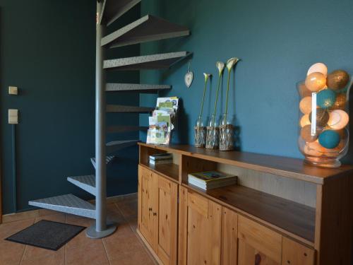 a spiral staircase in a room with a wooden cabinet at Family Home in Sourbrodt in Sourbrodt