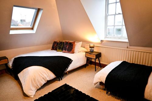 a bedroom with two beds and a window at Cathedral Cottage in Canterbury