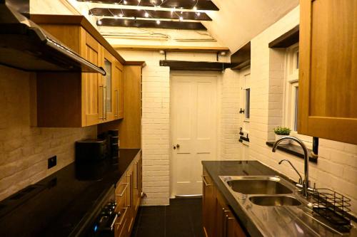 a kitchen with a sink and a white door at Cathedral Cottage in Canterbury