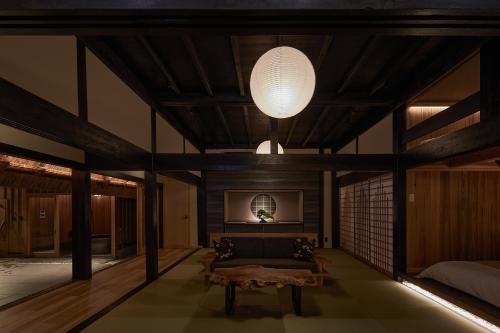 a room with a bed and a table and a lamp at えにし美山 霞月 -kagetsu- in Nantan city