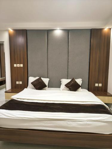 a large bed with two pillows on top of it at فندق جراند روز in Najran