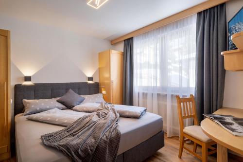 a bedroom with a bed with a window and a desk at Chalet Veronika in Fieberbrunn