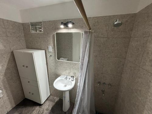 ein Badezimmer mit Waschbecken, Spiegel und Dusche in der Unterkunft Casa necochea in Necochea