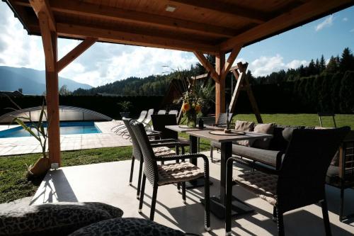 un patio con tavolo e sedie e una piscina di Kamp Nirvana a Šmartno ob Dreti