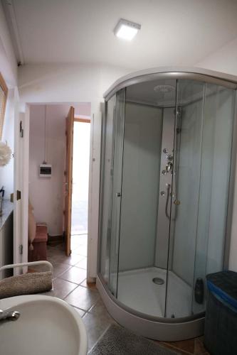 eine Glasdusche in einem Badezimmer mit Waschbecken in der Unterkunft Kamp Nirvana in Šmartno ob Dreti