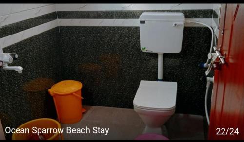 a bathroom with a toilet and a trash can at Ocean Sparrow Home Stay in Gokarna