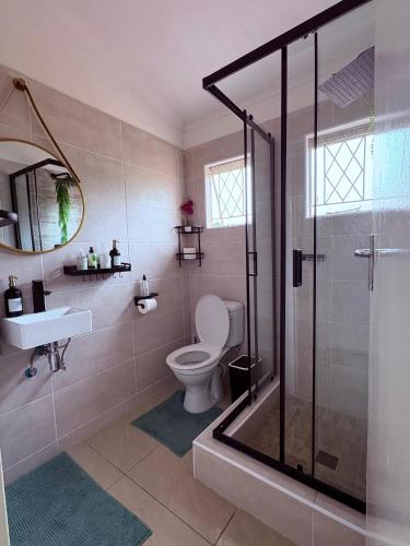 un bagno con doccia, WC e lavandino di The August Home a Gaborone
