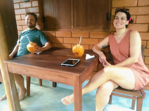 迪克韦勒Lunuvila Resort Hiriketiya Dikwella的坐在木桌旁的男人和女人