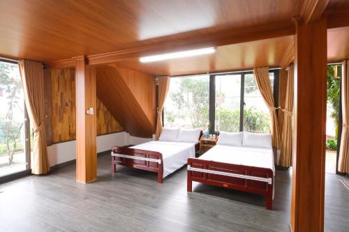 a bedroom with two beds and a window at Cỏ Mây Wonder Homestay in Mộc Châu