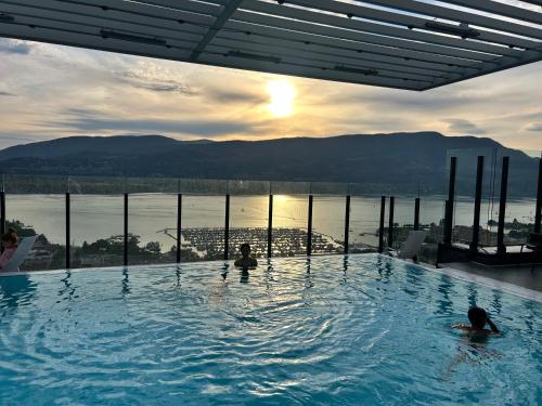 una piscina con due persone in acqua di Stunning Lake Views - downtown 2 Bedroom apartment - rooftop lounge a Kelowna
