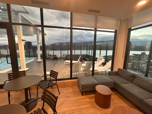 un soggiorno con un divano, un tavolo e delle sedie di Stunning Lake Views - downtown 2 Bedroom apartment - rooftop lounge a Kelowna