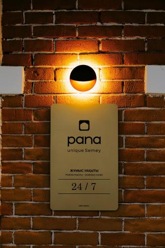 a sign for a parmaarmaarma company on a brick wall at Pana Unique Semey in Semey