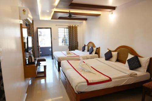 a hotel room with two beds in a room at Hotel Kailash Heaven in Madikeri