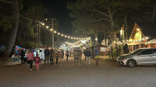 een groep mensen die 's nachts over straat lopen bij Jacaranda Mar Azul in Mar Azul