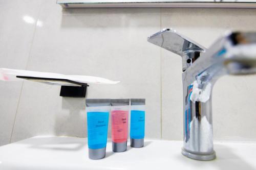 een wastafel met drie tandenborstels ernaast een kraan bij Friendly Hotel Yerevan in Jerevan