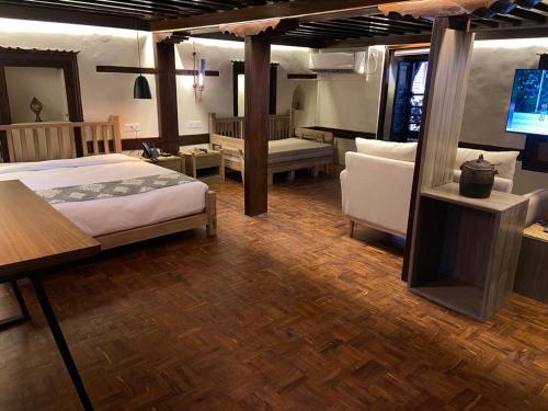 una camera da letto con un letto, un divano e una televisione di Hotel Thamel House - 6 km from Boudhanath Stupa, Kathmandu a Kathmandu