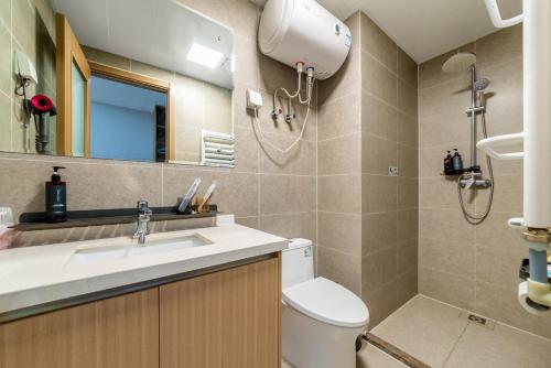 a bathroom with a sink and a toilet and a mirror at MountTai Twilight Elegance Lodge in Tai'an