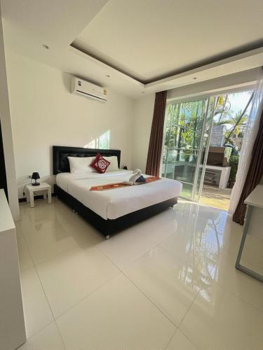 a bedroom with a bed and a large window at Villa with private pool in Kamala in Kamala Beach