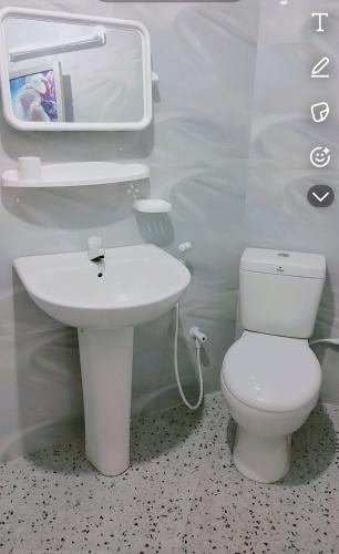 a bathroom with a white toilet and a sink at HindaHaven in Weligama