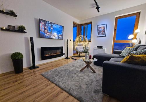 een woonkamer met een bank en een tv aan de muur bij Bansko St Ivan Rilski Residences in Bansko