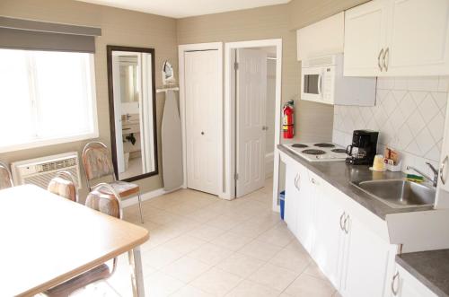 a kitchen with white cabinets and a sink at Best Budget Inn & Suites Kamloops in Kamloops