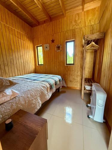 a bedroom with a bed in a wooden room at Home Quillon in Quillón