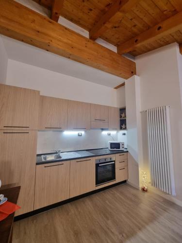 een keuken met houten kasten en een kookplaat met oven bij M&M apartments in Monclassico