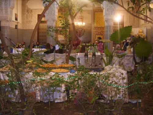 a group of people sitting around a table with plants at Riad Les Chrifis Navette Aéroport 24 sur 24 in Fès
