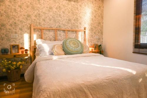 a bedroom with a bed with a wooden head board at בקתת שקד Shaked Cabin in Natur