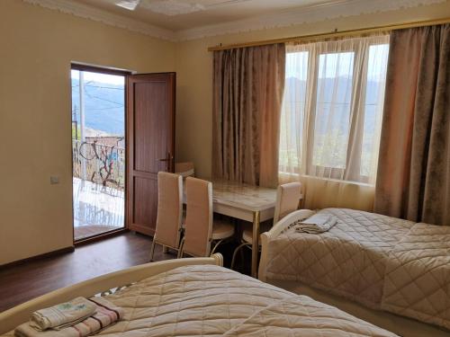 une chambre avec deux lits et une table et une fenêtre dans l'établissement Aspet B&B in Tatev, à Tatev