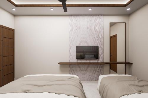een slaapkamer met 2 bedden en een tv aan de muur bij Hotel Liora Suites in Bangalore