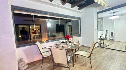 una sala da pranzo con tavolo e sedie e una grande finestra di AlaMar Cala Mijas Relax Premium Panoramic Sea Views SemiPenthouse a La Cala de Mijas