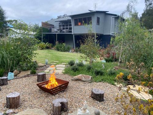 a fire pit in a yard in front of a house at Murramarang Haven in Bawley Point