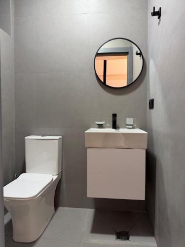 a bathroom with a white toilet and a mirror at 10 minutes from skiing in Bakuriani