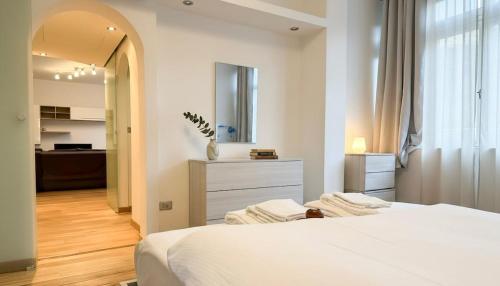 a white bedroom with a bed and a bathroom at Fiume 34 - bilocale luminoso e moderno a Sondrio in Sondrio