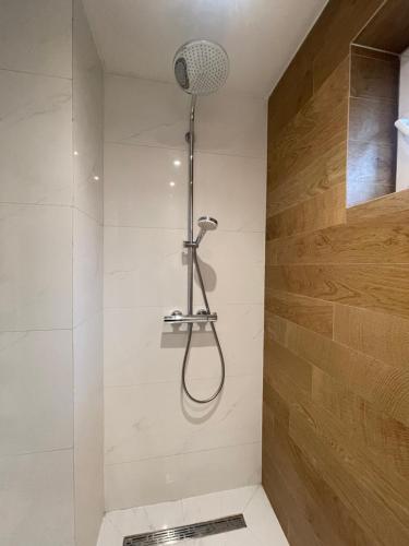 a shower with a shower head in a bathroom at The Gallery Apartment in Prishtinë