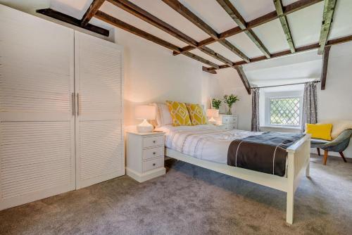 een slaapkamer met een bed, een stoel en een raam bij 2 Bed in Advent oc-s6025 in Camelford