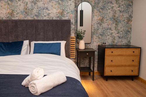 een slaapkamer met een bed en een dressoir met een spiegel bij Amber Hotel with access to shared kitchen in Hull