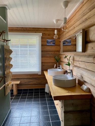 a bathroom with two sinks and a window at The Moose Lodge Swedish Nature Retreat in Bräcke