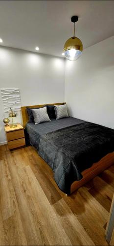 a bedroom with a large bed with a black comforter at Cabedelo Studio Residence in Viana do Castelo