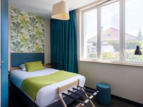 une chambre avec un lit, une fenêtre et une chaise dans l'établissement ibis Styles Calais Centre, à Calais