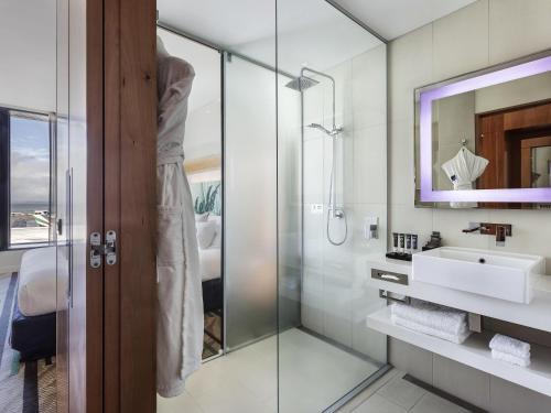 een badkamer met een glazen douche en een wastafel bij Novotel Auckland Airport in Auckland