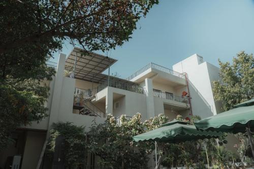 a white building with a balcony and an umbrella at Ramat Niwas By Kutani Stays in Jaipur