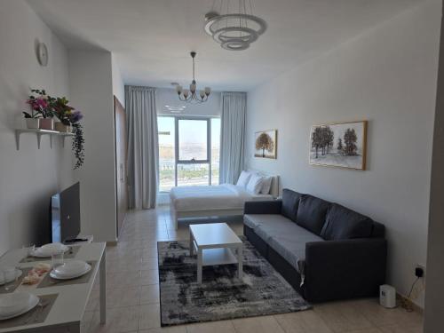 a living room with a couch and a bed at Skycourts - Well furnished Studio apartment in Dubai