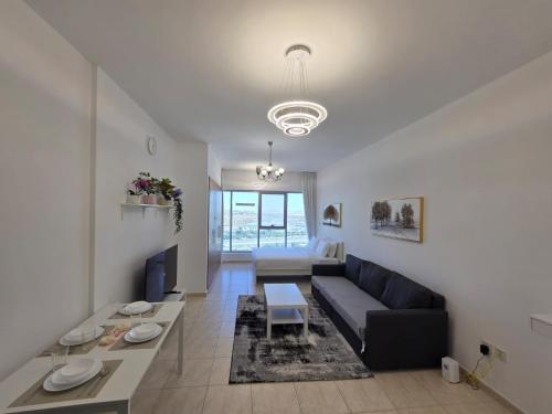 a living room with a couch and a table at Skycourts - Well furnished Studio apartment in Dubai