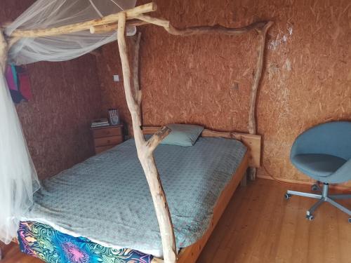 een slaapkamer met een hemelbed en een stoel bij Kurandero Temple in Bensafrim