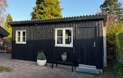 een zwarte schuur met een bank en twee ramen bij Amazing Home In Odder With Sauna in Odder