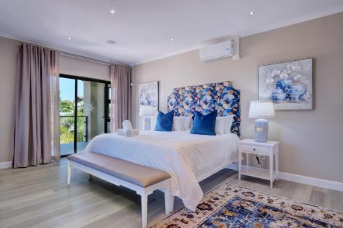 a bedroom with a large bed with blue pillows at Ahoy Boutique Hotel in Gqeberha